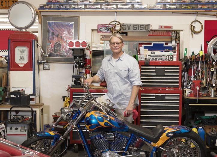 man at an motorcycle repair shop doing well. his small business must have a great website.