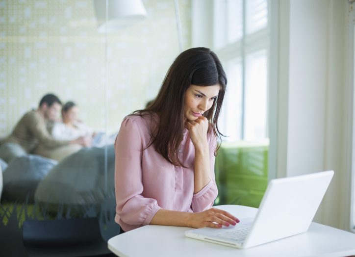Young businesswoman using laptop at office table to update her wordpress theme